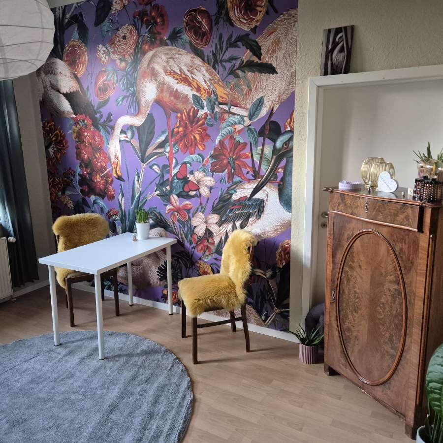 Beratungsplatz mit Blumenwand, Tisch, Stühlen und warmer Einrichtung