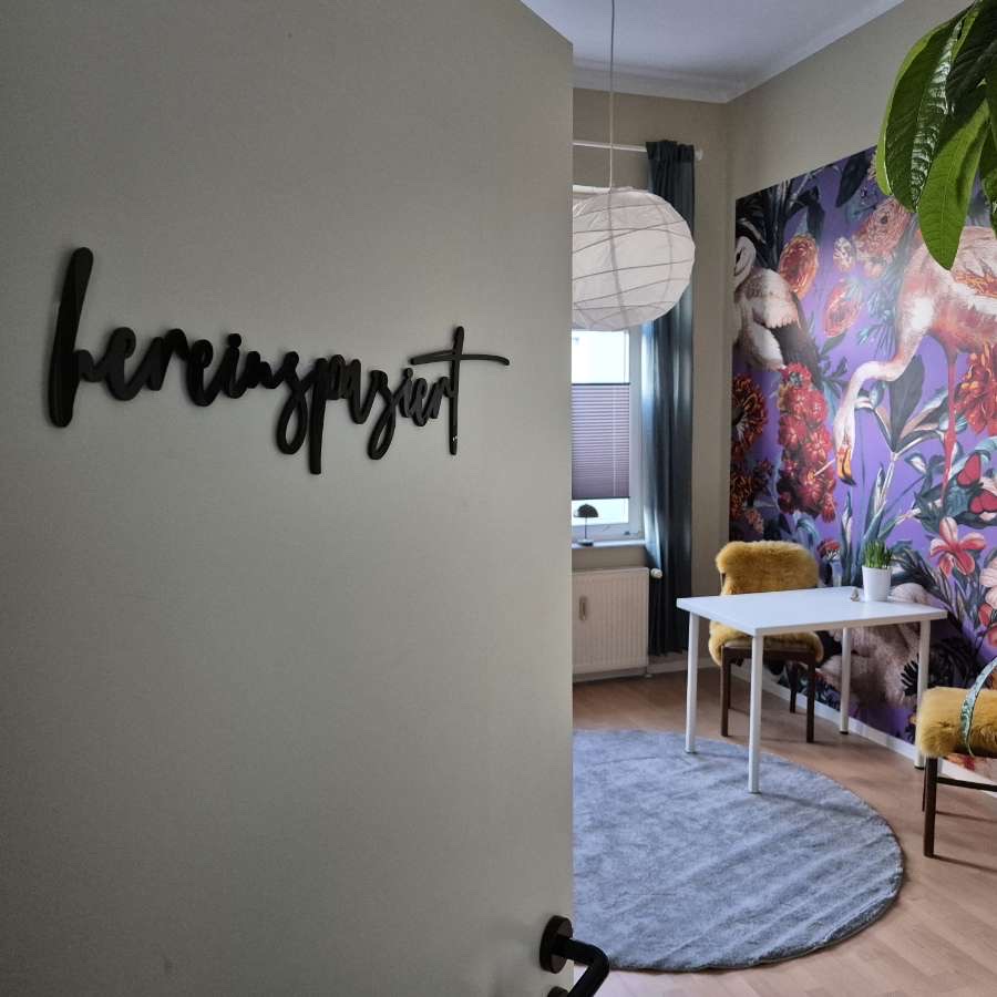 Eingang zum Praxisraum mit Schriftzug und Blick auf den Beratungsplatz